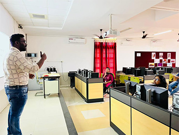Two men in bicycle jerseys sitting outside at table having coffee